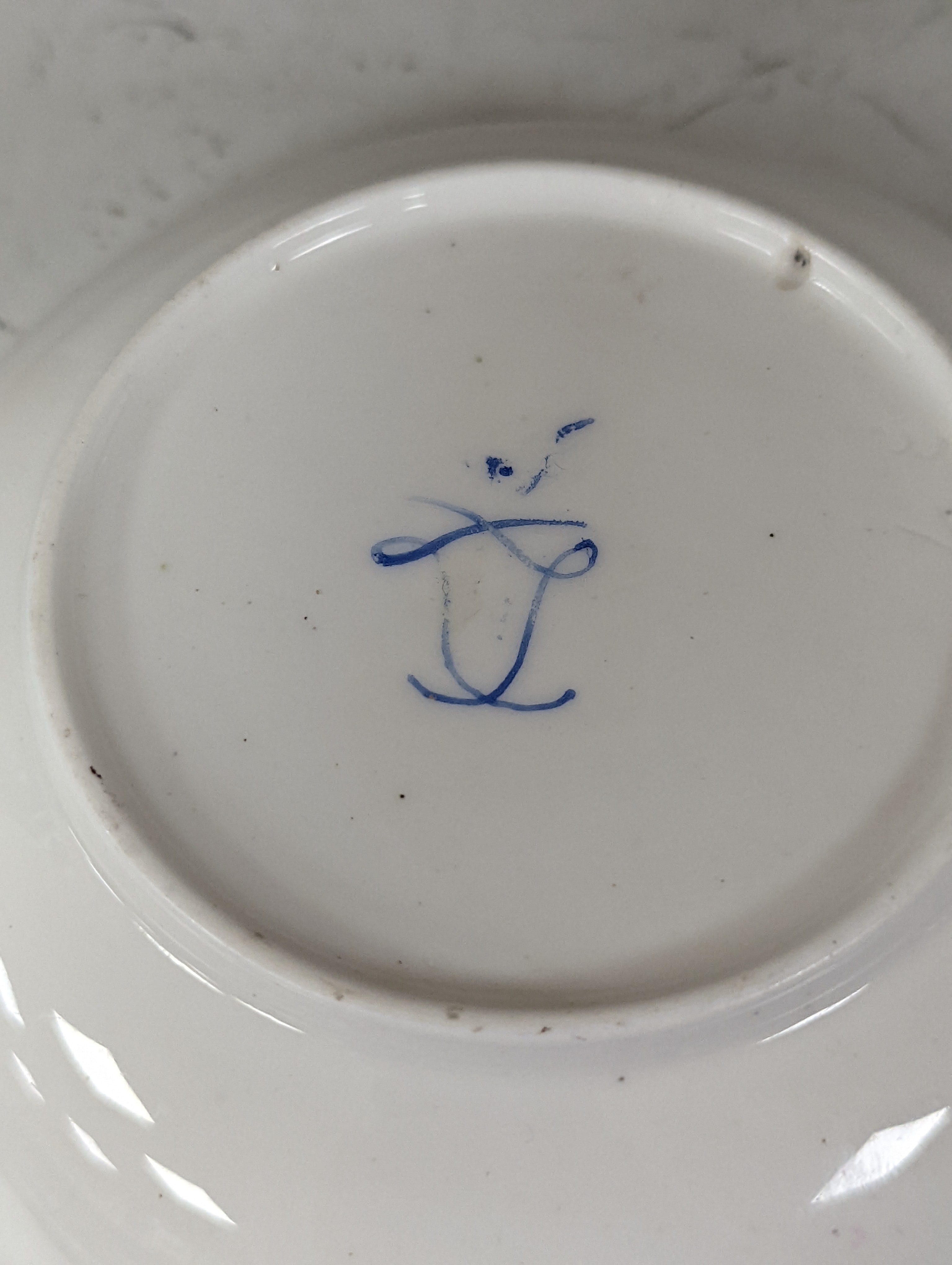 A Sevres coffee cup and saucer painted with floral bouquets under a dentil gilt and blue line border, date code 
